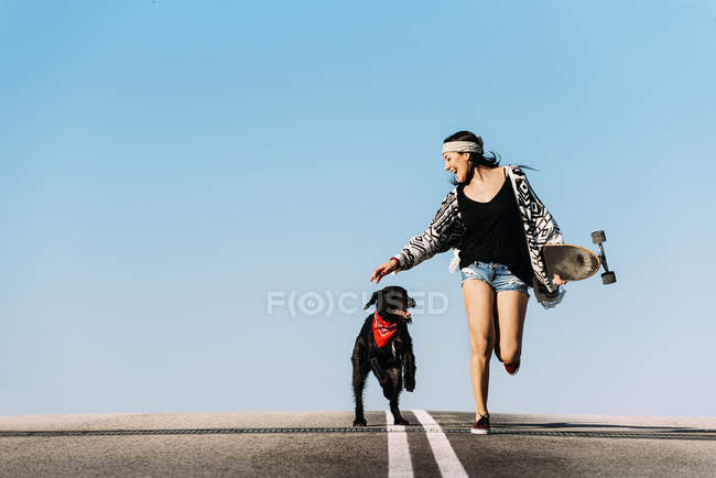 Jovem bonita brincando com seu cão . — Fotografia de Stock