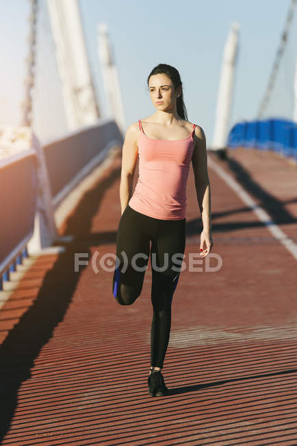 Jovem fitnesswoman corredor alongamento pernas após corrida . — Fotografia de Stock