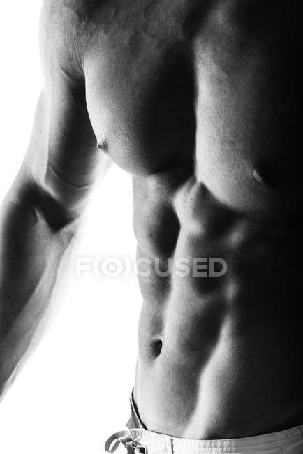 Primo piano del ragazzo bodybuilder muscolare facendo esercizi con pesi isolati sul bianco. Monocromatico — Foto stock