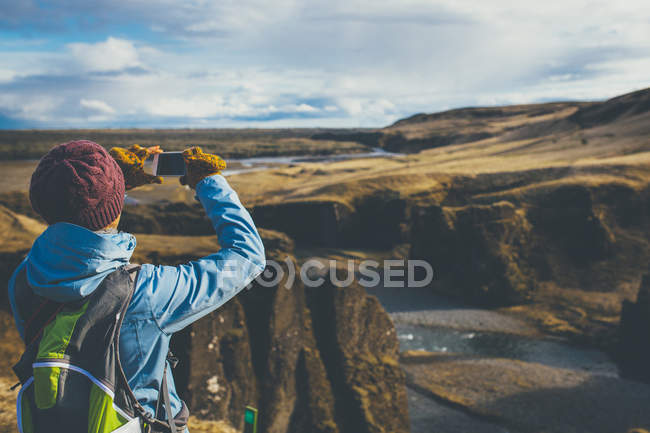 Donna che indossa abiti invernali scattare foto in Islanda — Foto stock
