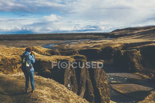 Donna che indossa abiti invernali scattare foto in Islanda — Foto stock