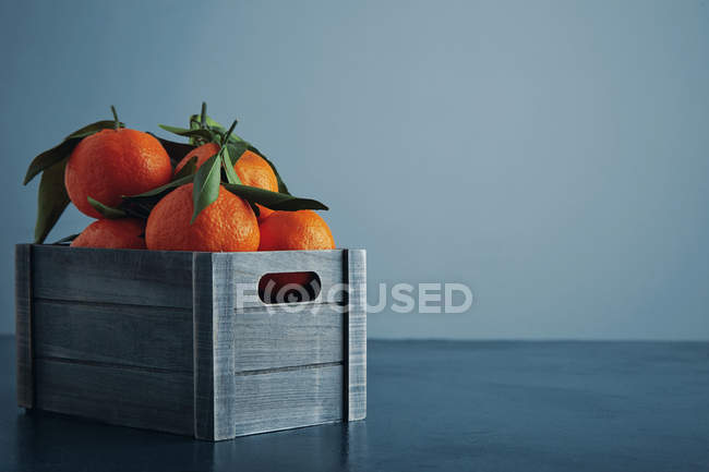Tangerinas frescas em caixa com folhas isoladas perto — Fotografia de Stock