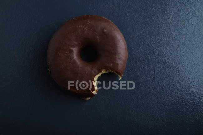 Vista superior mordida donut chocolate — Fotografia de Stock