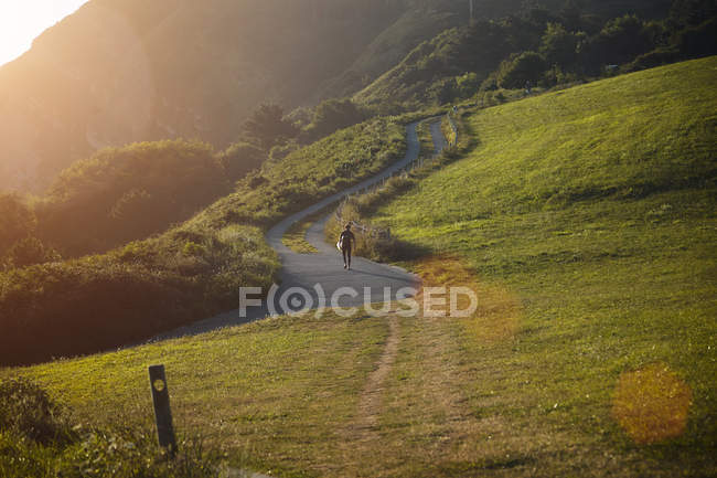 Surfista che sale in collina su strada tortuosa — Foto stock