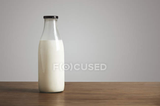 Bouteille vierge avec du lait sur la table — Photo de stock