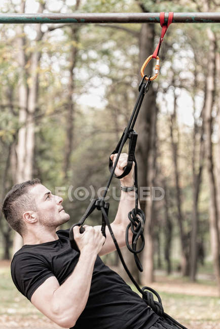 Homem exercitando com tiras de fitness — Fotografia de Stock