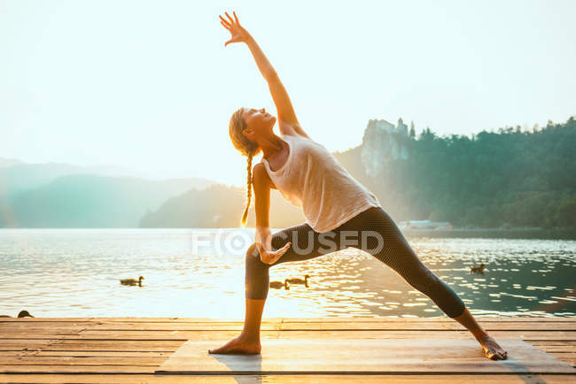 Donna che pratica Yoga in riva al lago — Foto stock