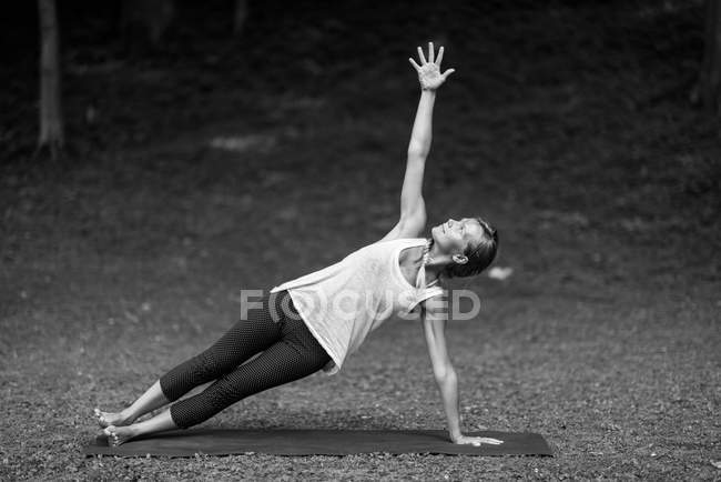 Fille faisant pose de planche latérale — Photo de stock