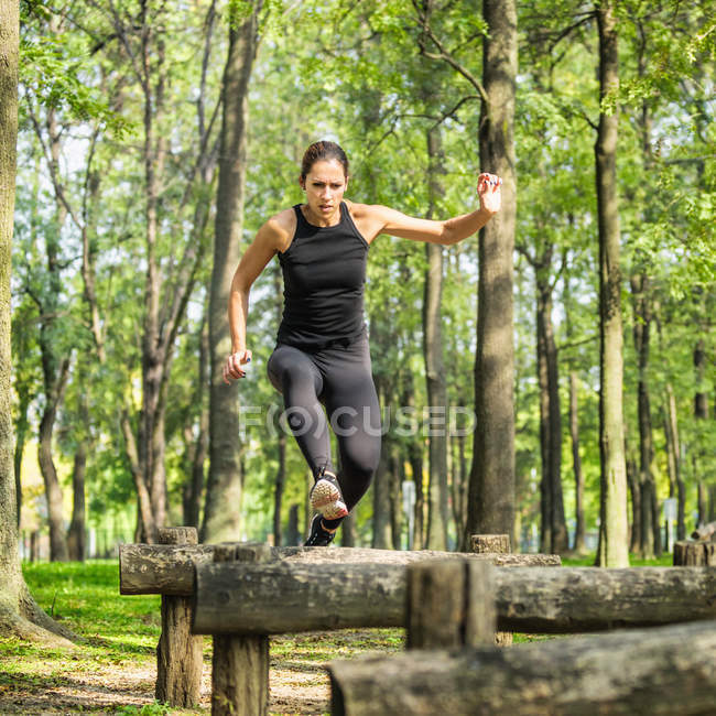 Atleta femenina cruzando obstáculos - foto de stock