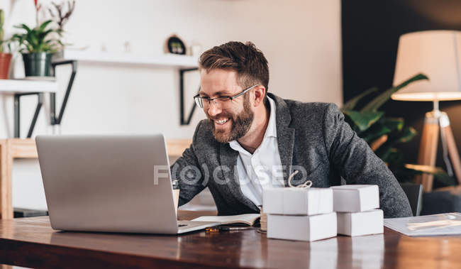 Unternehmer arbeitet am Laptop, während er am Tisch sitzt — Stockfoto