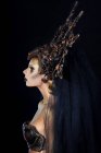 Vista lateral da mulher com maquiagem fantasia em grande coroa — Fotografia de Stock