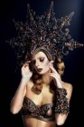 Mulher com maquiagem fantasia vestindo grande coroa e rosto comovente — Fotografia de Stock