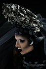 Profile of with fantasy makeup wearing large crown — Stock Photo