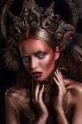 Porträt einer Frau mit modischem Make-up und Körperkunst mit Krone — Stockfoto