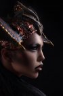 Profile of woman with fashion makeup wearing dragon style crown — Stock Photo
