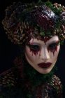 Женщина с окровавленным макияжем в фантазийной одежде и короне — стоковое фото