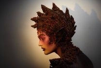 Profil einer jungen Frau mit Fantasie-Make-up-Kunst und floralen Dekorationen — Stockfoto