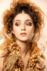 Mulher elegante atraente com maquiagem dourada e coroa olhando para longe — Fotografia de Stock