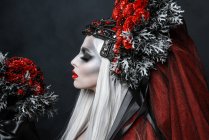 Портрет модної молодої жінки в костюмі на Хелловін і вінку в студії — стокове фото