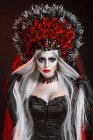 Porträt einer modischen jungen Frau in Halloween-Kostüm und Kranz im Atelier — Stockfoto