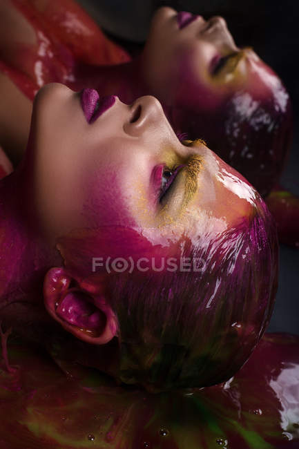 Profile of woman with fantasy makeup and paint on hair — Stock Photo