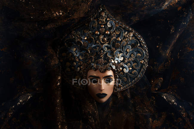 Portrait of woman with fantasy makeup wearing large crown — Stock Photo