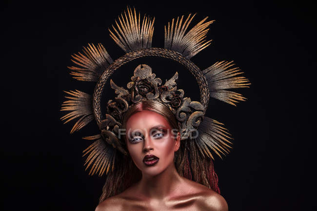 Retrato de mujer con maquillaje de moda y arte corporal llevando corona - foto de stock