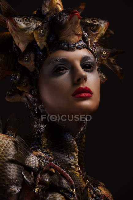 Portrait of female monster with headdress and clothes made from fishes — Stock Photo