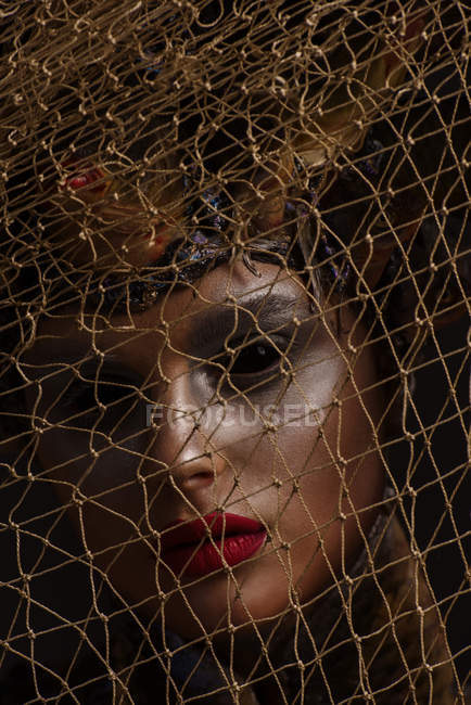 Closeup portrait of female monster with headdress and clothes made from fishes posing with net — Stock Photo