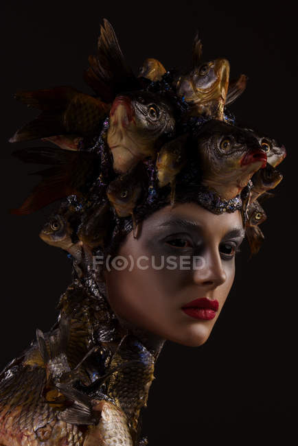 Portrait of female monster with headdress and clothes made from fishes — Stock Photo