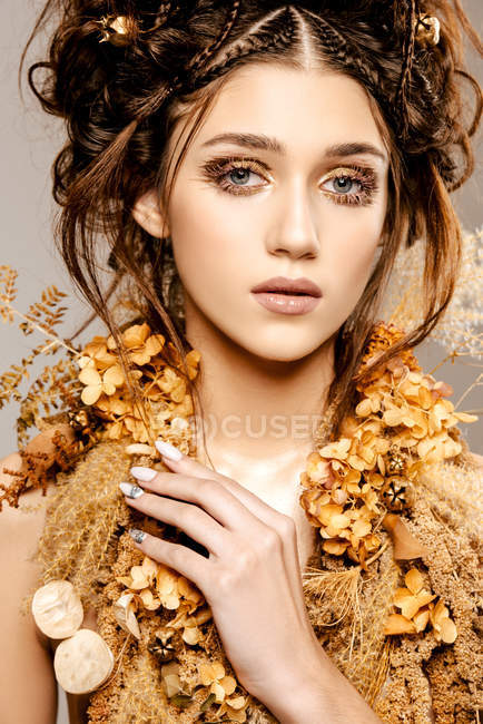 Привлекательная модная женщина с золотым макияжем и венком, смотрящая в камеру — стоковое фото