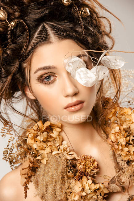 Attraktive modische Frau mit goldenem Make-up und Kranz blickt in die Kamera — Stockfoto