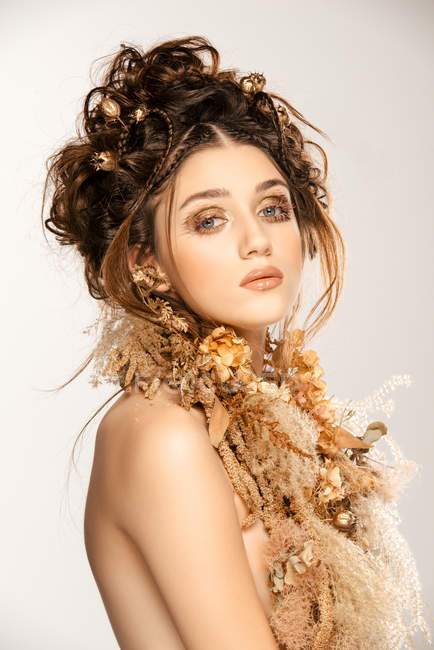 Attractive fashionable woman with golden makeup and wreath looking at camera — Stock Photo