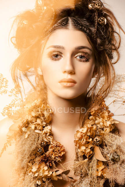 Attractive fashionable woman with golden makeup and wreath looking away — Stock Photo