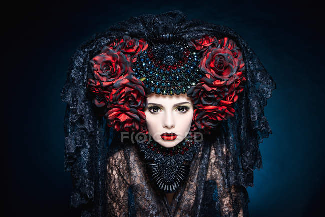 Модна стрілянина жінки з вуаллю і червоними квітами — стокове фото