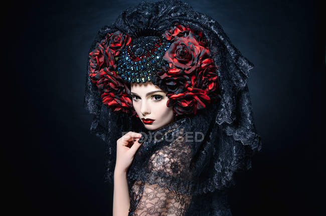 Fashionable shoot of woman with veil and red flowers — Stock Photo
