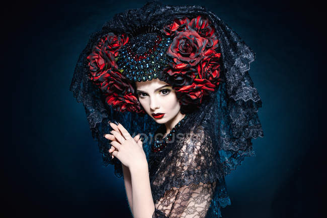 Модная съемка женщины с вуалью и красными цветами — стоковое фото