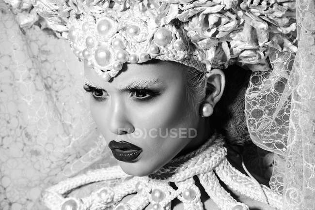 Модная женщина с белой короной позирует в студии — стоковое фото