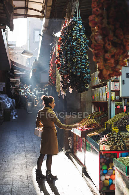 Woman chooses in the market nuts — Stock Photo