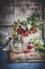 Gooseberries and red currants in glass jar — Stock Photo