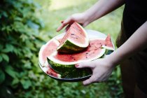 Frauenhände mit aufgeschnittener Wassermelone — Stockfoto