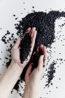 Human hands and black beans — Stock Photo
