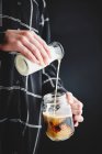 Женщина наливает молоко в кофе — стоковое фото