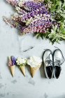 Цветы в вафельных рожках с туфлями — стоковое фото