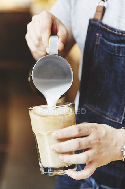 Barista in apron making coffee — Stock Photo