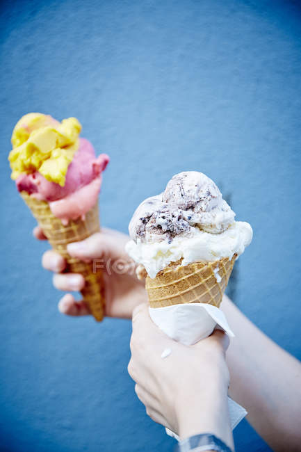 Manos sosteniendo deliciosos helados - foto de stock