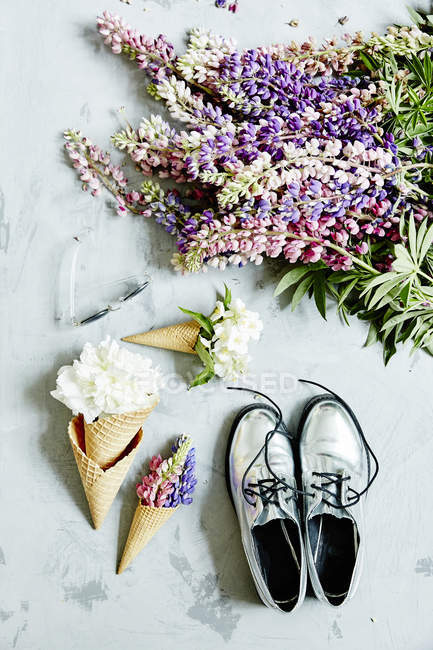 Blumen in Waffelkegeln mit Schuhen — Stockfoto