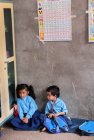 Niño y niña sentado en el aula de la escuela - foto de stock