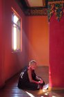 Young monk in sunlight inside monastery — Stock Photo