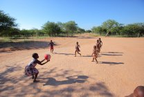 Дети играют в футбол в сельской школе — стоковое фото